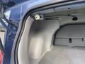 Interior view of the trunk space of a 2007 Chrysler PT Cruiser showing a gray carpeted floor and storage compartment with accessories attached to the side