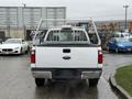 White 2008 Ford F-250 Super Duty truck viewed from the rear with a metal rack in the bed and a clean exterior