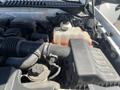 Close-up view of the engine compartment of a 2013 Ford Expedition showcasing the air intake, various hoses, and a coolant reservoir