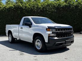 A white 2021 Chevrolet Silverado 1500 pickup truck with a black grille and chrome wheels positioned at an angle