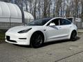 A 2019 Tesla Model 3 in white with black rims parked at an angle showcasing its sleek design and modern features