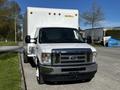 A white 2019 Ford Econoline van with a large cargo box in the back and a black front grille parked on a street