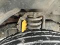 Close-up of a suspension spring and yellow shock absorber mounted on a 2009 Ford Econoline with a visible tire in the foreground
