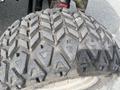 Close-up of a worn tire from a 2012 Toro Groundsmaster 5910 featuring a distinctive tread pattern with deep grooves and angled cuts