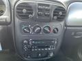 The interior dashboard of a 2005 Chrysler PT Cruiser featuring climate controls and a radio display with buttons and dials