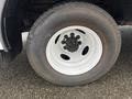 A white wheel with a silver rim and black lug nuts from a 2012 Ford Econoline van