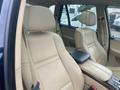 Interior of a 2009 BMW X5 featuring beige leather seats with a center console and headrests visible