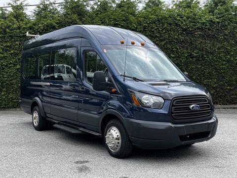 A 2017 Ford Transit 350 van with a dark blue exterior features a high roof and large windows designed for passenger transport