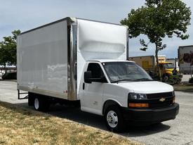 A white 2020 Chevrolet Express cargo van with a large blank box-shaped cargo area and a black front grill parked on a paved surface