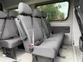 Interior seats of a 2017 Mercedes-Benz Sprinter van featuring multiple rows of gray upholstered seats with seatbelts