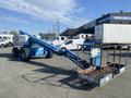 A blue 1997 Genie S-65 4X4 aerial lift with a long boom extended and a work platform attached at the end