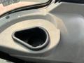 A close-up view of a cup holder located in the interior of a 2010 Kubota M6040 tractor