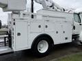 A 2005 Freightliner M2 106 utility truck with a white body and multiple storage compartments on the side