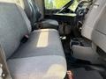 A gray fabric driver seat of a 2009 Kenworth T270 with a black console and gear shifter nearby