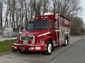 A red 1994 Freightliner FL80 fire truck with the words "FIRE DEPT" displayed prominently on the front and equipped with emergency lights and a rescue compartment