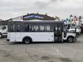 A white 2017 Chevrolet Express bus with large side windows and a rear entry door parked in a lot