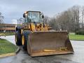 A 2008 Hyundai XG 350 with a large front loader bucket is positioned in the foreground displaying its wheels and yellow coloration