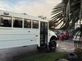 A white 2015 International 3000 bus is parked with its front visible featuring large windows and a door that is partially open