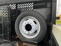 A white wheel with a black tire mounted on a black trailer with a perforated design on the side