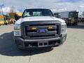 A white 2013 Ford F-250 Super Duty truck with a black grille and amber lights visible on the front