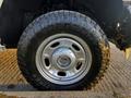 Close-up of a silver 2012 Ford F-250 wheel with a rugged tire featuring the brand name Open Country