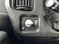 A close-up of the control panel in a 2006 GMC C5000 with a dial for headlight adjustment and various function switches