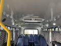 Interior of a 2012 Chevrolet Express van featuring blue seats and patterned curtains against a white ceiling