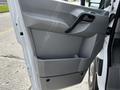 Door panel of a 2017 Mercedes-Benz Sprinter with a handle and storage compartment in gray plastic