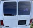 A white 2002 Ford Econoline van with tinted rear windows and a blank license plate holder