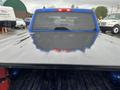 A 2019 RAM 1500 Classic truck viewed from the rear with a flatbed and a shiny, wet surface reflecting light