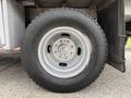 Close-up of a 2015 Ford F-350 SD tire mounted on a wheel with a silver rim and visible lug nuts
