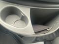 A 2004 Ford Econoline's center console with two cup holders and a small black zipper pouch resting inside