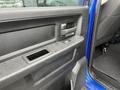 Close-up of the interior door panel of a 2019 RAM 1500 Classic featuring a textured black surface with a window control switch and a small storage compartment