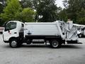 A white 2014 Hino 195 garbage truck with a compact design and side-loading mechanism is shown from the side angle