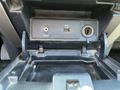 A 2014 Ford F-150's center console with a compartment showing a USB port and a line-in audio input