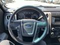Interior view of a 2014 Ford F-150 steering wheel with controls and instrument panel visible