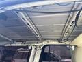 The interior roof of a 2013 Ford Expedition showing the metal framework and wiring without insulation or coverings