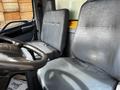 Interior of a 2006 Hino 268 showing two black vinyl seats and a steering wheel in the foreground