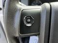 A close-up of the steering wheel controls of a 2016 Ford F-550 featuring buttons for setup info and reset