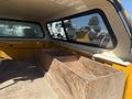 A yellow 2013 Chevrolet Silverado 1500 with a modified truck bed featuring a wooden compartment in the back