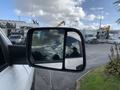 A 2021 RAM 1500 side mirror reflecting clouds and surroundings