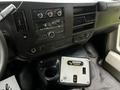 Dashboard of a 2017 Chevrolet Express featuring a radio control panel and climate controls with a center console displaying switches and a cup holder