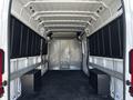 Interior view of a 2017 RAM Promaster cargo van showing empty space with two wooden boxes along the sides and metal shelves mounted on the walls