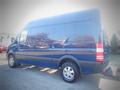 A blue 2017 Mercedes-Benz Sprinter van with a high roof and large cargo space is parked, showcasing its sleek design and sturdy tires