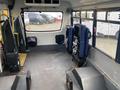 Interior of a 2016 Chevrolet Express showing two blue seats and an empty space with a gray floor