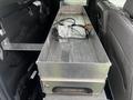 A metallic storage box is installed in the bed of a 2017 Ford F-150 with a cable connected to it