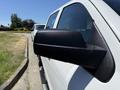 A side mirror of a white 2016 GMC Sierra 1500 showcasing its sleek design and angular shape
