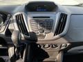 Dashboard of a 2017 Ford Transit featuring a central control panel with buttons for audio and climate, a gear shift, and a digital display showing the time