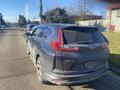 A gray 2019 Honda CR-V parked on the street with a dusty exterior and visible license plate