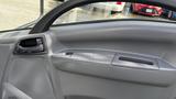 Interior door panel of a 2016 Isuzu NPR featuring controls for windows and door handle